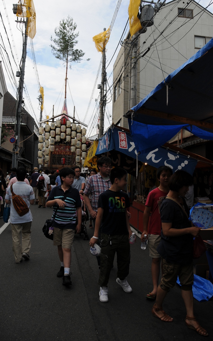 street scene with food stalls and float in the background