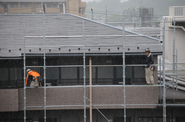 putting up a scaffolding in the pouring rain