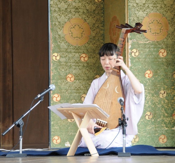 a woman playing on a biwa